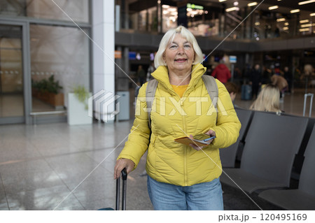 Young female traveler walking with a blue suitcase at the modern transport stop outdoors. Concept of an urban transportation and travel 120495169