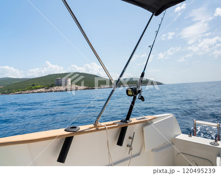 Relaxing day on a boat with fishing gear and scenic coastal landscape 120495239