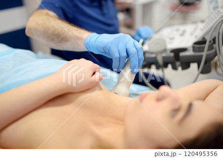 Mammologist doctor examines a woman breasts and lymph nodes using ultrasound. Mammography and ultrasound scanning are main methods of instrumental diagnosis of mammary glands. Breast cancer 120495356