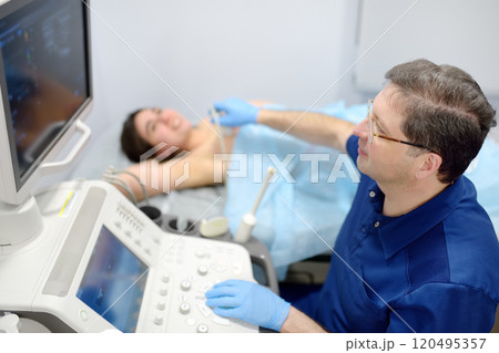 Mammologist doctor examines a woman breasts and lymph nodes using ultrasound. Mammography and ultrasound scanning are main methods of instrumental diagnosis of mammary glands. Breast cancer 120495357