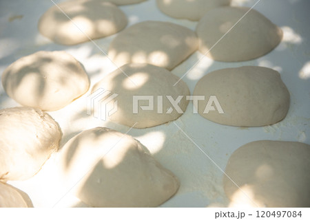 Balls of fresh homemade dough on floured wooden board. 120497084