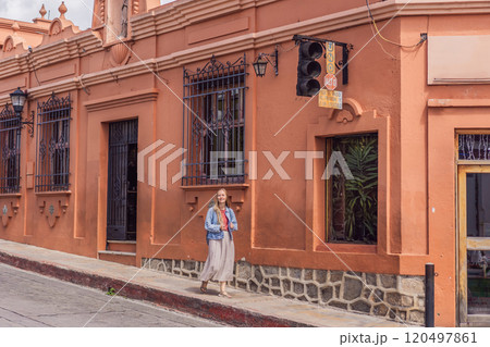 Female tourist walks through the colonial streets San Cristobal de las Casas, Mexico. Cultural exploration, architecture, and travel experience concept 120497861