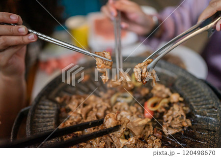A Group of Friends Enjoying a Truly Delicious BBQ Feast Together at a Grill Table 120498670