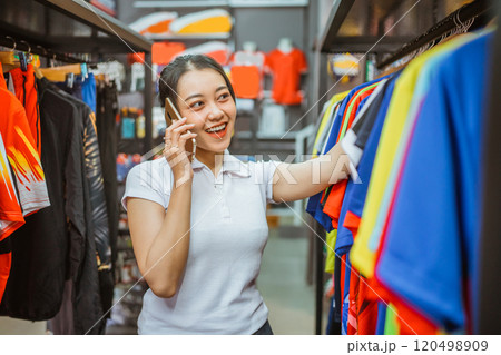 female sportswear store staff speaking phone female sportswear store staff speaking phone 120498909