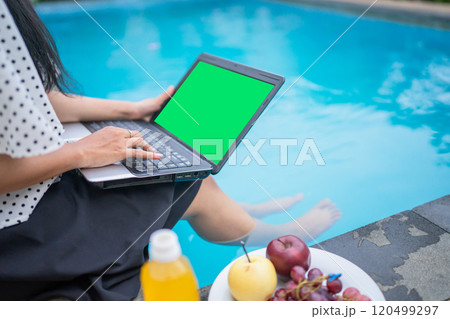 Working by the Pool Enjoying a Relaxing Laptop Lifestyle in a Beautiful, Serene Setting 120499297