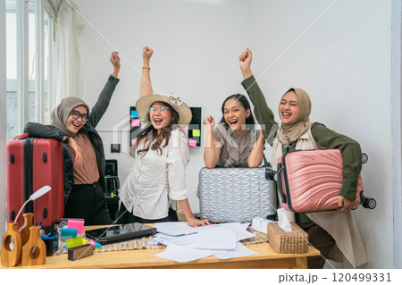A Joyful Group of Friends Celebrating Together with Their Luggage in a Modern Workspace 120499331