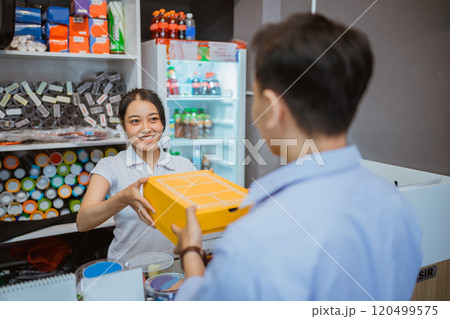 female staff hand over product male customer female staff hand over product male customer 120499575