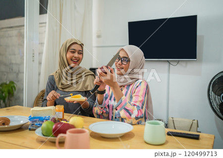 Friends joyfully enjoying breakfast at home, creating moments of happiness together 120499713