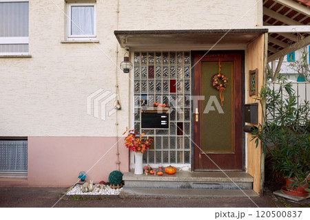 Elegant Entryway Showcasing a Beautiful Glass Door Decorated with Halloween Pumpkins: A Warm Welcome to Your Home. 120500837