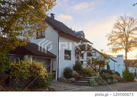 Charming House Beautifully Surrounded by Lush Greenery During the Lovely Autumn Season Charming House Beautifully Surrounded by Lush Greenery During the Lovely Autumn Season 120500873