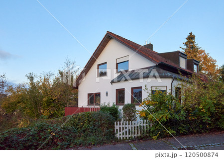 Charming House Beautifully Surrounded by Lush Greenery During the Lovely Autumn Season 120500874