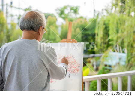 Lifestyle Asian senior old man painting picture artwork using brush and oil color on canvas, elderly people smile paint at his easel outside green nature background, Happy retirement artist activity Lifestyle Asian senior old man painting picture artwork using brush and oil color on canvas, elderly people smile paint at his easel outside green nature background, Happy retirement artist activity 120504721