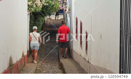 Elderly couple walking in a narrow cobblestone street in Brazil Elderly couple walking in a narrow cobblestone street in Brazil 120504749