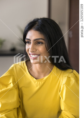 Positive dreamy beautiful Indian woman in yellow cloth looking away Positive dreamy beautiful Indian woman in yellow cloth looking away 120505109