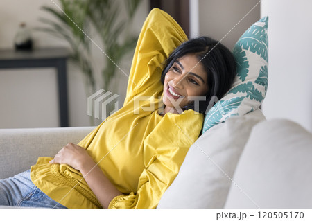 Happy young Indian woman resting on white soft couch Happy young Indian woman resting on white soft couch 120505170