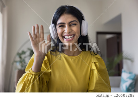 Cheerful young Indian influencer girl in headphones greeting blog audience Cheerful young Indian influencer girl in headphones greeting blog audience 120505288