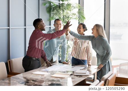 Cheerful successful multiethnic business team giving group high five Cheerful successful multiethnic business team giving group high five 120505290