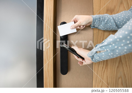 Cropped shot of female hands opening door with key card 120505588