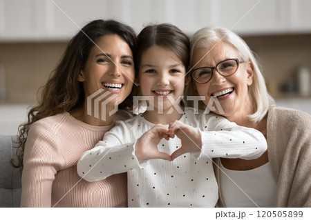Loving little girl posing for camera with mom and granny Loving little girl posing for camera with mom and granny 120505899