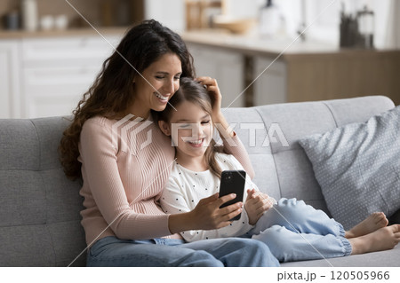 Loving mom and little daughter spending carefree leisure with smartphone 120505966