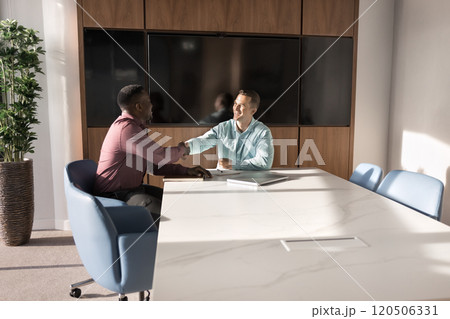 Two successful multiethnic business men shaking hands in office Two successful multiethnic business men shaking hands in office 120506331