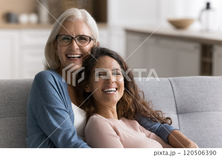 Middle-aged mother and millennial 35s daughter relaxing together on couch Middle-aged mother and millennial 35s daughter relaxing together on couch 120506390