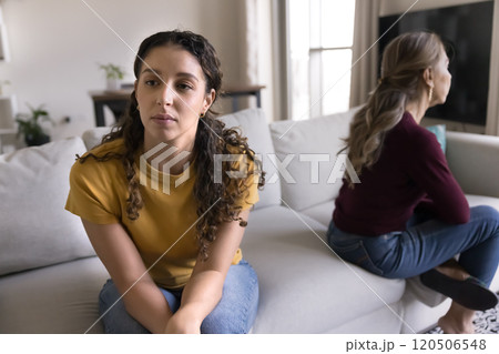 Upset Latin daughter woman sitting separately from senior mom Upset Latin daughter woman sitting separately from senior mom 120506548