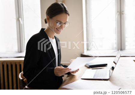 Smiling businesswoman reading message on cellphone at workplace 120506577