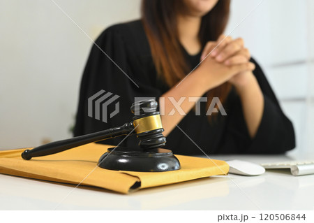 A gavel hammer mallet poised above a sound block symbolizing legal authority and justice 120506844