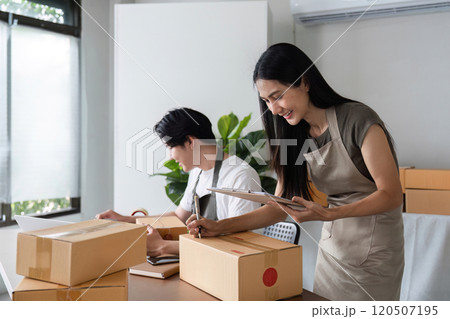Couple Managing Online Business Inventory and Checking Product Stock in Modern Home Office Setting 120507195