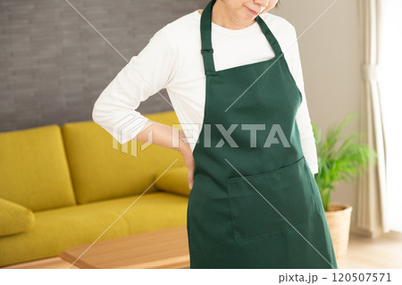 腰痛に苦しむエプロン姿のミドル女性 腰痛に苦しむエプロン姿のミドル女性 120507571