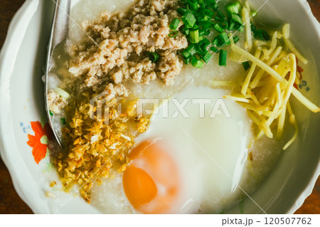 Hot Chinese congee (rice porridge) with minced pork on wooden table 120507762