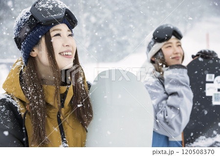 ゲレンデで雪降る空を見るスノボ女子　女子旅 120508370