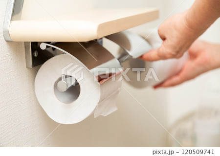 新しいトイレットペーパーを補充するミドル女性の手元 120509741
