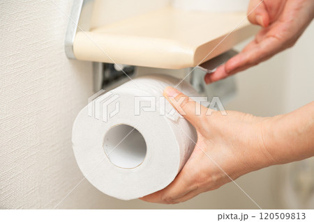 新しいトイレットペーパーを補充するミドル女性の手元 120509813