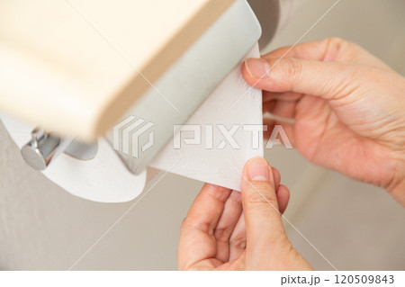 新しいトイレットペーパーを三角折りするミドル女性の手元 新しいトイレットペーパーを三角折りするミドル女性の手元 120509843