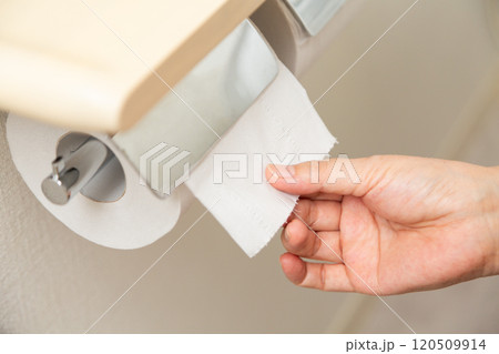 トイレットペーパーを使うミドル女性の手元 トイレットペーパーを使うミドル女性の手元 120509914