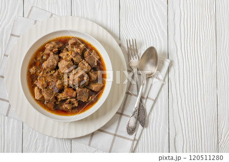 beer braised pork stew in a white bowl 120511280