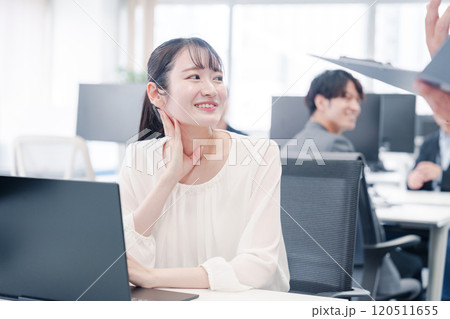 オフィスで楽しく雑談をする若い女性 オフィスで楽しく雑談をする若い女性 120511655