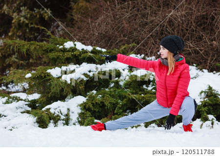 Woman wearing sportswear exercising outside during winter Woman wearing sportswear exercising outside during winter 120511788