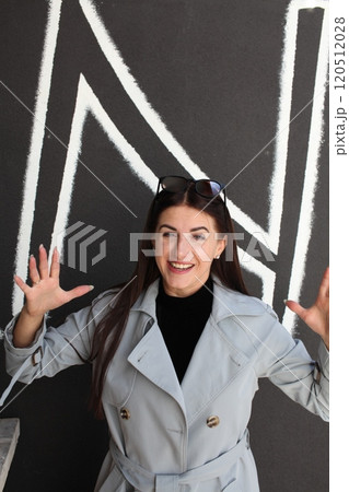 young pretty brunette woman posing emotional outside on neutral background 120512028