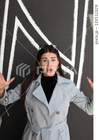 young pretty brunette woman posing emotional outside on neutral background 120512029