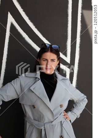 young pretty brunette woman posing emotional outside on neutral background 120512053