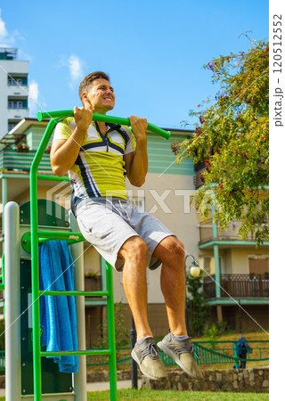 Man doing pull ups in outdoor gym 120512552