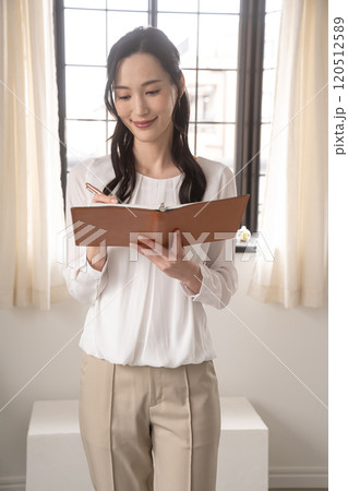 システム手帳を見る若い女性 システム手帳を見る若い女性 120512589