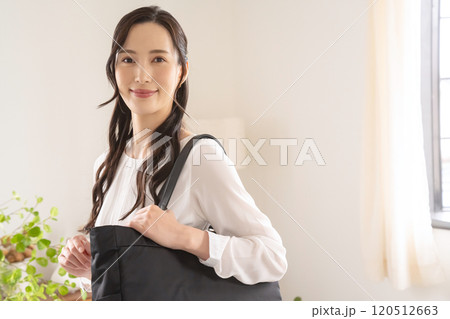 屋内でバッグを肩にかける女性 屋内でバッグを肩にかける女性 120512663