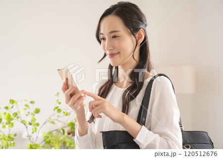 屋内でスマホを操作するビジネスウーマン 屋内でスマホを操作するビジネスウーマン 120512676
