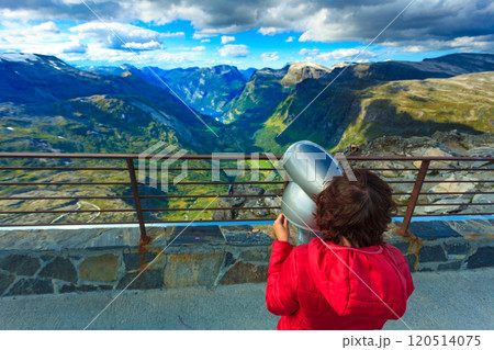 Tourist looking through binoculars in mountains, Norway 120514075