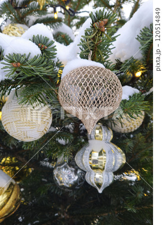 Branches of Christmas tree with beautiful decorations covered with snow 120514849