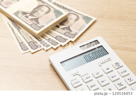テーブルに置かれた106万円と電卓 テーブルに置かれた106万円と電卓 120516853